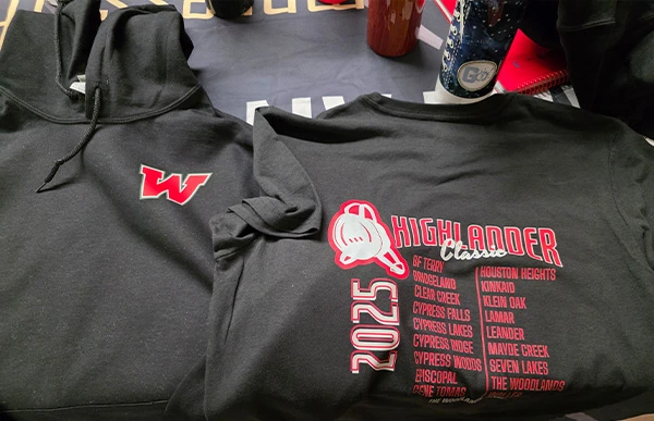 Black 2025 Highlander Classic hoodies displayed on a table, featuring the tournament logo and participating schools.